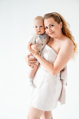 mom with a small child, mom with a newborn baby smiling, hugging, and kissing, happy family on a...