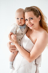 mom with a small child, mom with a newborn baby smiling, hugging, and kissing, happy family on a...