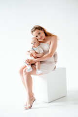mom with a small child, mom with a newborn baby smiling, hugging, and kissing, happy family on a...