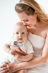 mom with a small child, mom with a newborn baby smiling, hugging, and kissing, happy family on a...