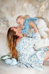 a mother with a small child, a mother with a newborn baby at home, smiling, hugging, and kissing, a...