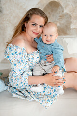 a mother with a small child, a mother with a newborn baby at home, smiling, hugging, and kissing, a...