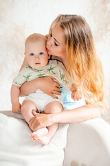 a mother with a small child, a mother with a newborn baby at home, smiling, hugging, and kissing, a...