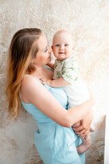 a mother with a small child, a mother with a newborn baby at home, smiling, hugging, and kissing, a...