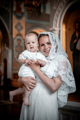 a mother with a small child in a church or cathedral, the baptism of a baby in a church, the...