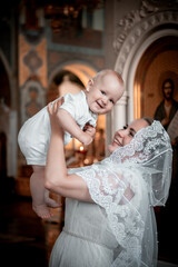 a mother with a small child in a church or cathedral, the baptism of a baby in a church, the...