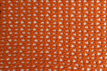 Beautiful openwork pattern made of bright orange cotton yarn, crocheted, on a light background....