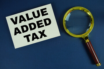 Value Added Tax text written on paper with magnifying glass