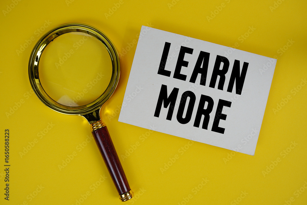 Poster learn more text written on paper with magnifying glass