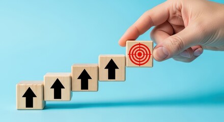 Business goal and success concept with hand placing target icon block on wooden stairs