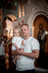 a father with a small child in a church or cathedral, the baptism of a baby in a church, the...