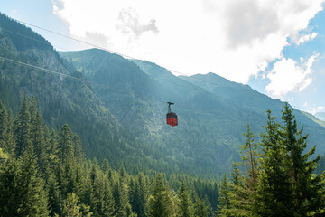 Cable car ascending over lush green valley in the transfagarasan, romania