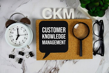 CKM - Customer Knowledge Management acronym with calculator, alarm clock and magnifying glass,...