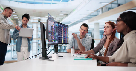 Diverse Team Utilizes Multiple Computers
