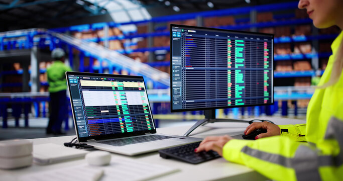 Woman Using Logistic Software On Warehouse Computer