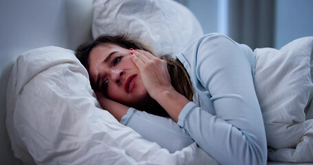 Sleep-deprived Woman With Insomnia Struggles In Dark Bedroom