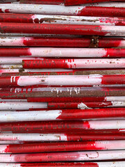 Stacked Red and White Pipes with Weathered Paint