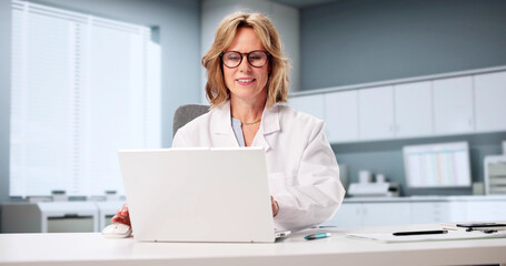 Female Doctor Uses Laptop For Online Doctor Consultations