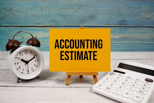 Accounting Estimate text written on paper card with calculator and alarm clock on wooden background