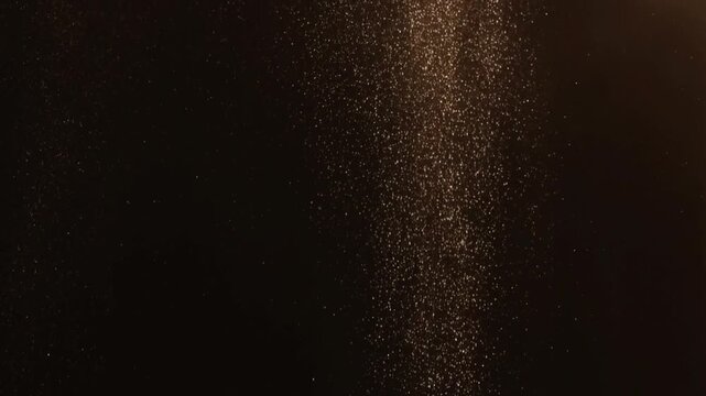 Glitter dust falling and catching light in slow motion