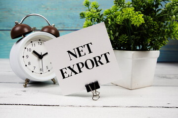 Net Export text written on paper card with alarm clock on wooden background