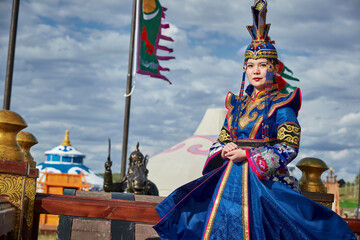 Mongolian girls dressed in luxurious Mongolian costumes on the Mongolian war chariots of the Jinyuan Grand Tent on the grassland