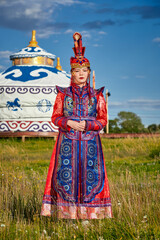 Obraz premium Mongolian girls dressed in luxurious Mongolian costumes in front of a yurt on the grassland