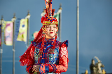 Naklejka premium Mongolian girls dressed in luxurious Mongolian costumes in front of a yurt on the grassland