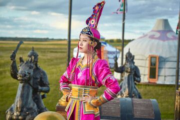 Mongolian girls dressed in luxurious Mongolian costumes on the Mongolian war chariots of the Jinyuan Grand Tent on the grassland