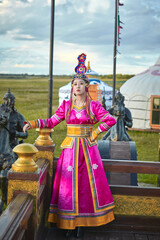 Naklejka premium Mongolian girls dressed in luxurious Mongolian costumes on the Mongolian war chariots of the Jinyuan Grand Tent on the grassland