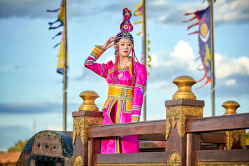 Mongolian girls dressed in luxurious Mongolian costumes on the Mongolian war chariots of the Jinyuan Grand Tent on the grassland
