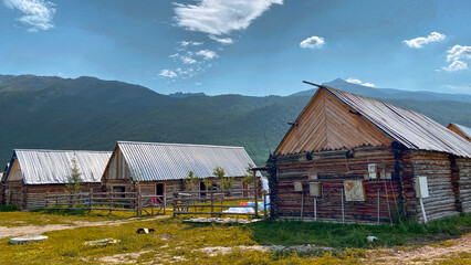 Rustic Wooden Cabins with Metal Roofs Set Against a Mountainous Landscape