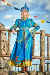 Obraz premium Mongolian girls dressed in luxurious Mongolian costumes in front of an obo on the grassland