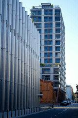 Modern Residential Skyscraper Beside Contemporary Metal Facade and Historic Brick Building