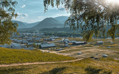 Rural Village Nestled in a Valley with Rolling Hills and Distant Mountains