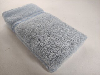 neatly folded light blue towel isolated on white background