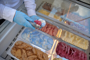 The ice cream man puts ice cream in the cone
