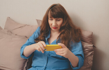Beautiful old woman chatting on smartphone, placing order online or reading social networks in...