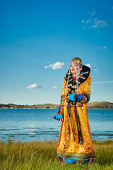 Fototapeta premium Mongolian girls dressed in luxurious Mongolian costumes on the grassland