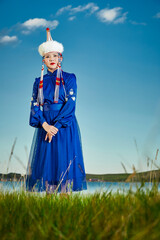 Fototapeta premium Young Mongolian sisters wearing traditional Mongolian clothing on the grassland