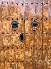 Ancient Wooden Door with Metal Studs and Ornate Knocker