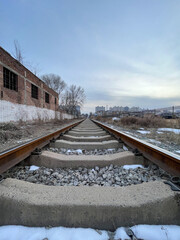 Railway Tracks Stretching into the Distance with Urban Buildings in Background