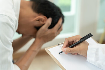 man with mental health problems is consulting. psychiatrist is recording the patient's condition...