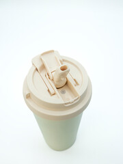 Beige open thermo mug with lid and straw on white background, close-up top view