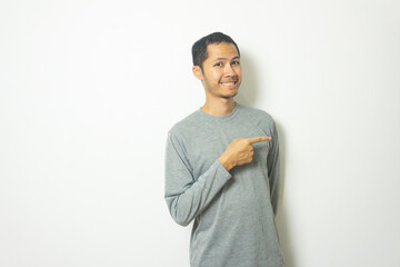young Adult Asian men wearing grey shirt pointing with finger with smile isolated white background