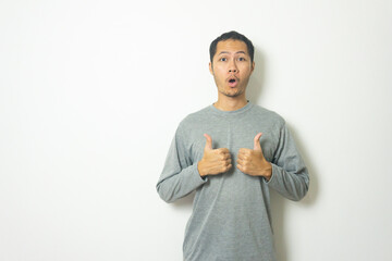 young Adult Asian men wearing grey shirt thumbs up with smile isolated white background
