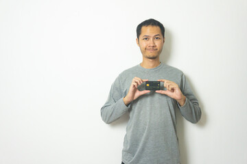 young Adult Asian men wearing grey shirt showing credit card isolated white background