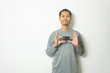 young Adult Asian men wearing grey shirt showing credit card isolated white background