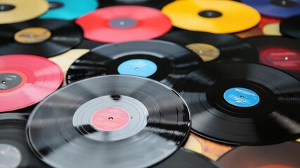 Collection of colorful vinyl records scattered across surface, showcasing various genres