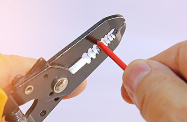 Stripping electrical copper wiring wires with a tool. 